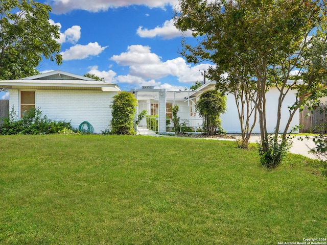 view of front facade with brick siding, concrete driveway, and a front lawn