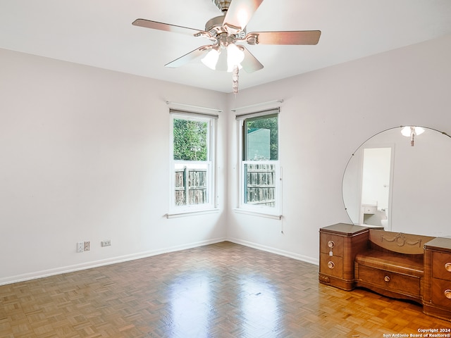 unfurnished room with ceiling fan and light parquet flooring