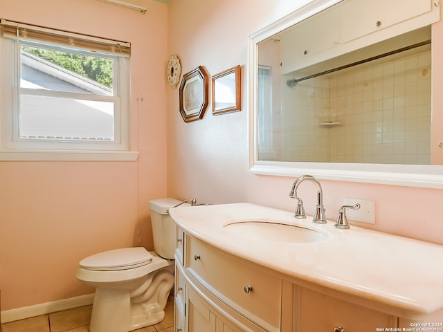 bathroom featuring vanity, toilet, tiled shower, and tile patterned flooring