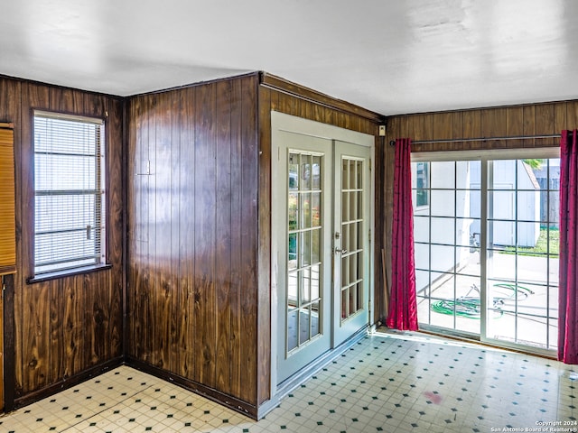 entryway with a wealth of natural light, wooden walls, and french doors