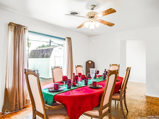 dining space with parquet flooring and ceiling fan