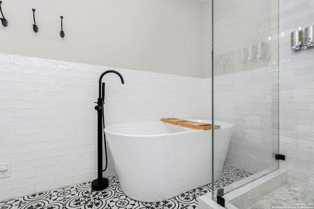 bathroom featuring tile patterned flooring and shower with separate bathtub