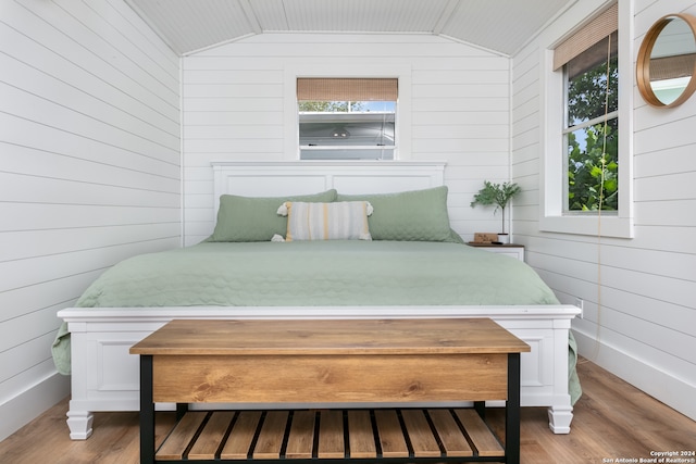 bedroom with hardwood / wood-style floors, multiple windows, and vaulted ceiling