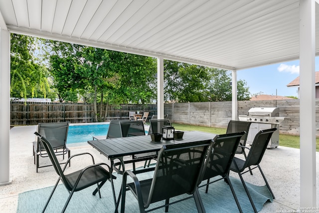 view of patio featuring a fenced in pool and area for grilling