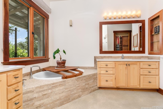 full bathroom featuring vanity, a relaxing tiled tub, and finished concrete floors