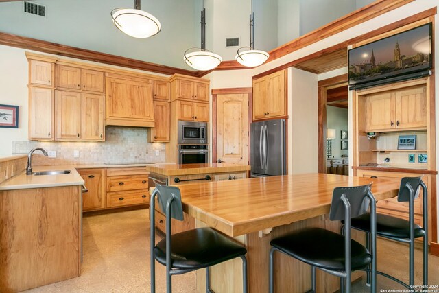 kitchen featuring appliances with stainless steel finishes, light brown cabinets, sink, and wooden counters