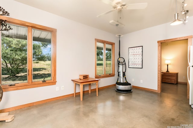 sitting room featuring a wealth of natural light and ceiling fan with notable chandelier