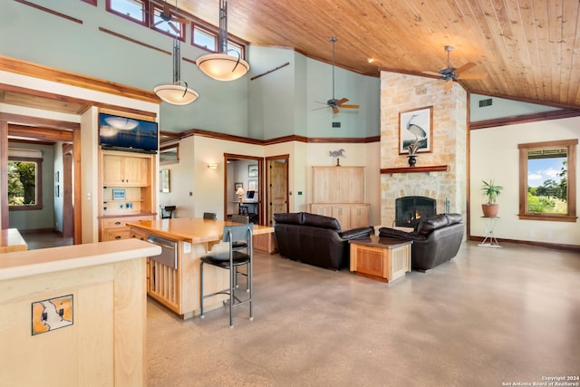 kitchen with a wealth of natural light, open floor plan, a stone fireplace, and ceiling fan