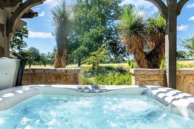 view of swimming pool featuring a hot tub