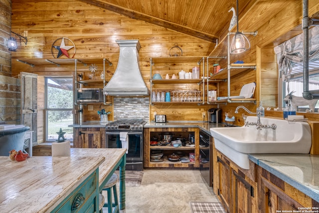 kitchen with a wealth of natural light, custom range hood, stainless steel gas stove, and lofted ceiling with beams