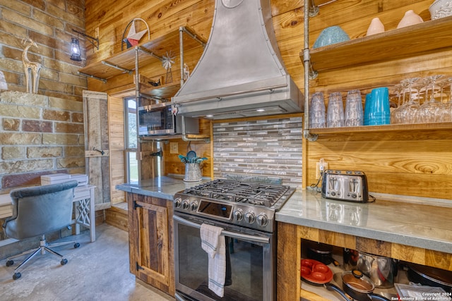 kitchen with wood walls, appliances with stainless steel finishes, custom exhaust hood, and concrete floors