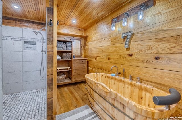 bathroom with a shower, hardwood / wood-style floors, wooden walls, and wooden ceiling