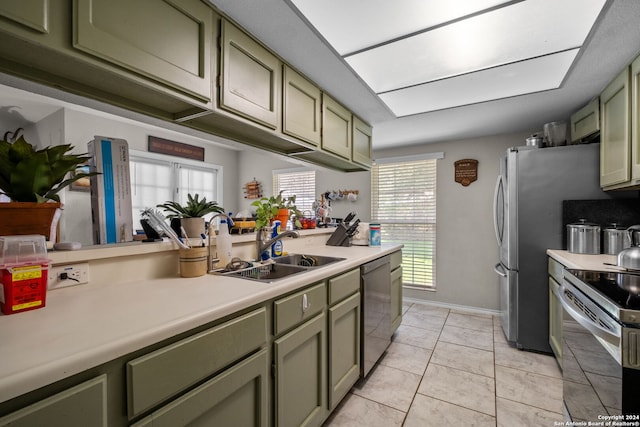 kitchen featuring green cabinetry, stainless steel appliances, light tile patterned flooring, and sink