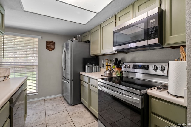 kitchen featuring appliances with stainless steel finishes, green cabinets, and light tile patterned floors