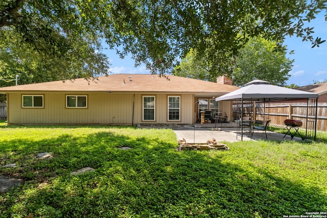 rear view of property with a yard and a patio area