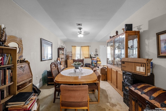 carpeted dining space featuring a textured ceiling and ceiling fan