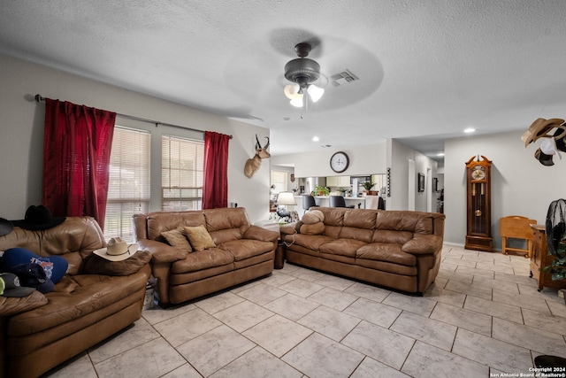 living room with a textured ceiling and ceiling fan