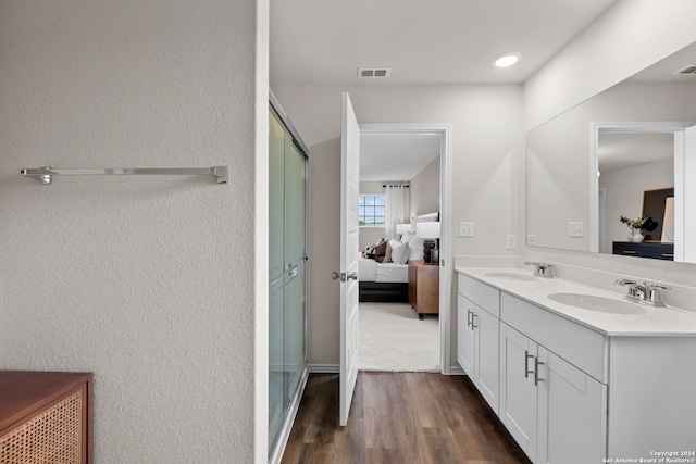 bathroom featuring hardwood / wood-style floors, a shower with door, and vanity