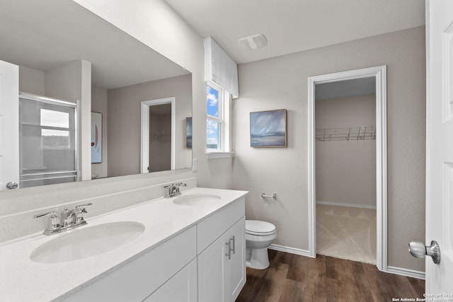 bathroom featuring vanity, toilet, hardwood / wood-style floors, and an enclosed shower