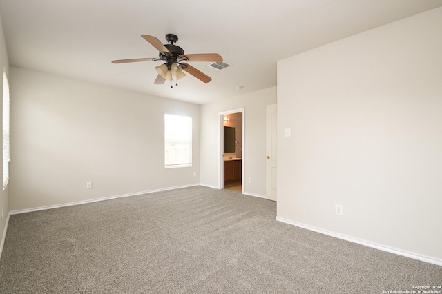 empty room featuring baseboards, visible vents, carpet, and a ceiling fan