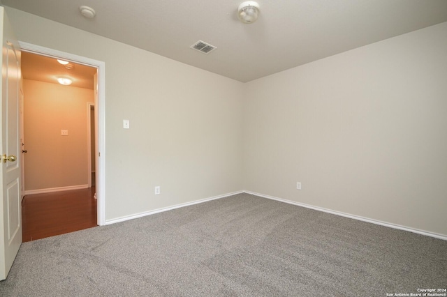 spare room with carpet flooring, baseboards, and visible vents