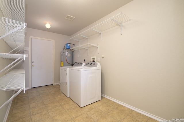 washroom featuring washing machine and dryer and electric water heater