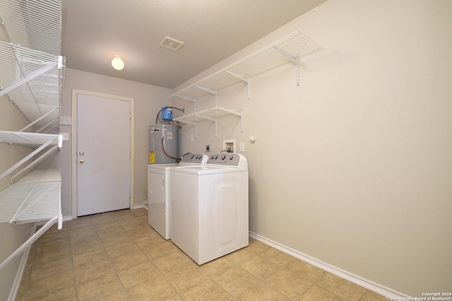 laundry room featuring electric water heater, baseboards, visible vents, washer and dryer, and laundry area
