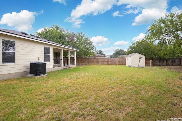 view of yard featuring an outdoor structure, a fenced backyard, central air condition unit, and a storage shed