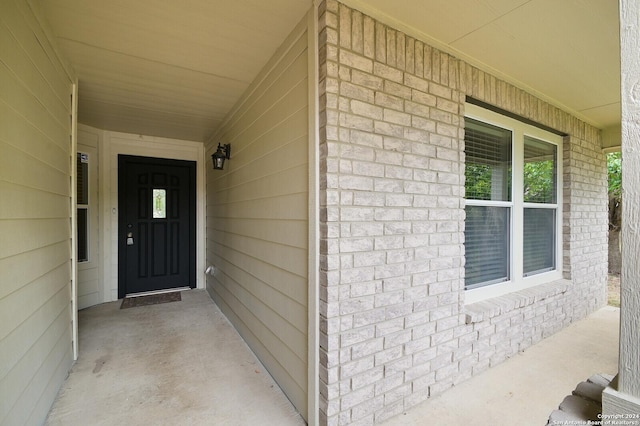 view of exterior entry with brick siding