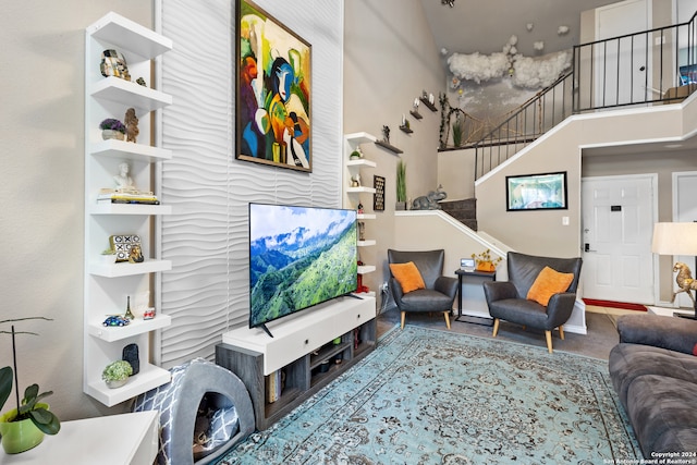 living room with a towering ceiling and hardwood / wood-style flooring