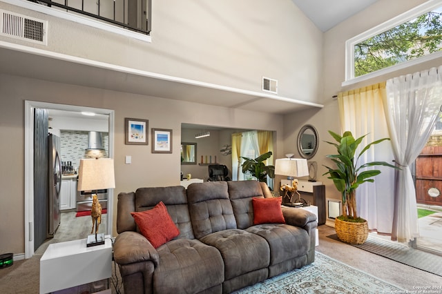 carpeted living room with a towering ceiling