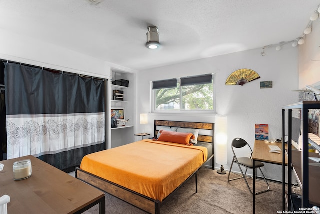 carpeted bedroom with a textured ceiling and a fireplace