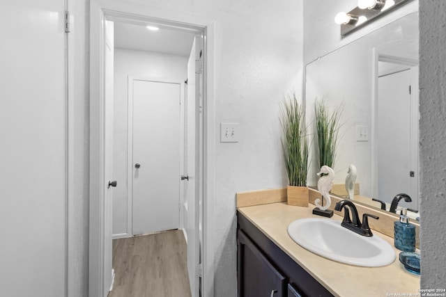 12019 Ashrock Ct, San Antonio, TX 78230 - bathroom featuring a textured wall, wood finished floors, and vanity