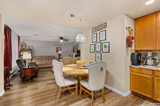 dining room with light hardwood / wood-style floors and ceiling fan