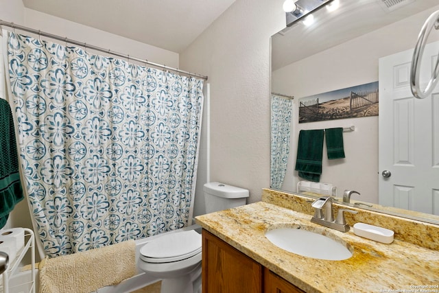 bathroom featuring vanity, toilet, and walk in shower