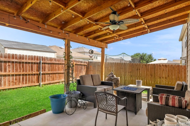 view of patio featuring ceiling fan and an outdoor living space with a fire pit