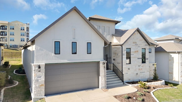 view of front of house with roof with shingles, stucco siding, a garage, stone siding, and driveway