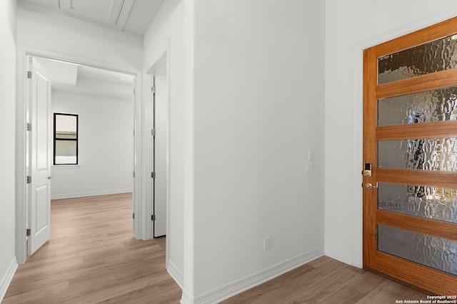 hallway with light wood-type flooring and baseboards