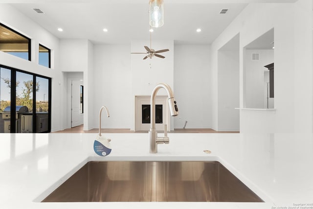 kitchen with recessed lighting, light countertops, a high ceiling, and a sink