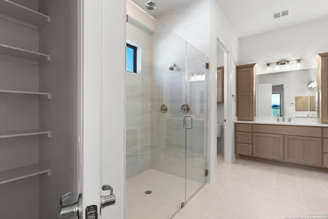 bathroom featuring toilet, a shower stall, plenty of natural light, and visible vents