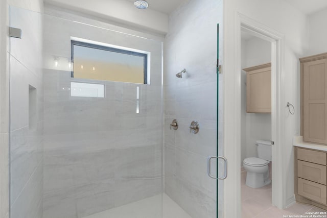 full bathroom featuring tile patterned flooring, a shower stall, and toilet