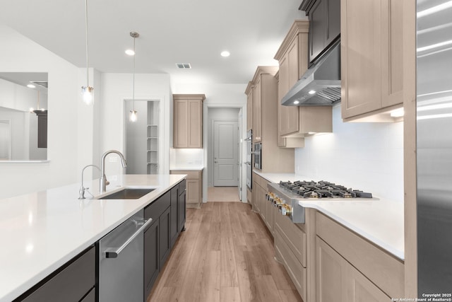 kitchen featuring visible vents, light wood-style flooring, stainless steel appliances, light countertops, and under cabinet range hood