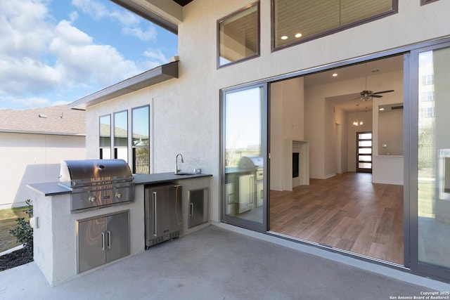 view of patio / terrace with an outdoor kitchen, a grill, and a sink