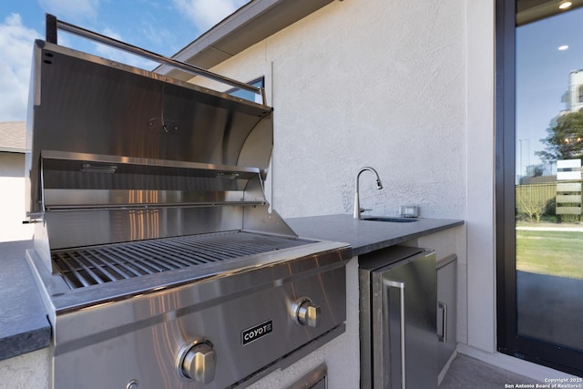 details featuring stucco siding, wine cooler, fridge, and a sink