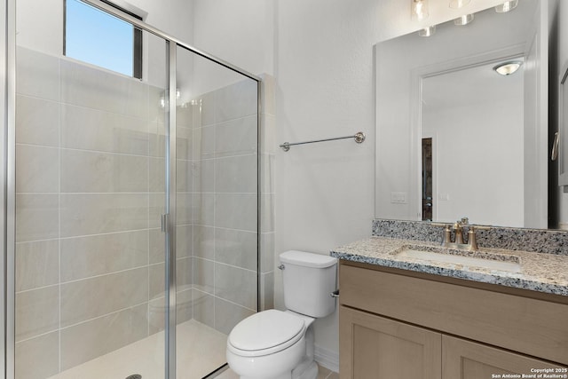 bathroom with a shower stall, toilet, and vanity