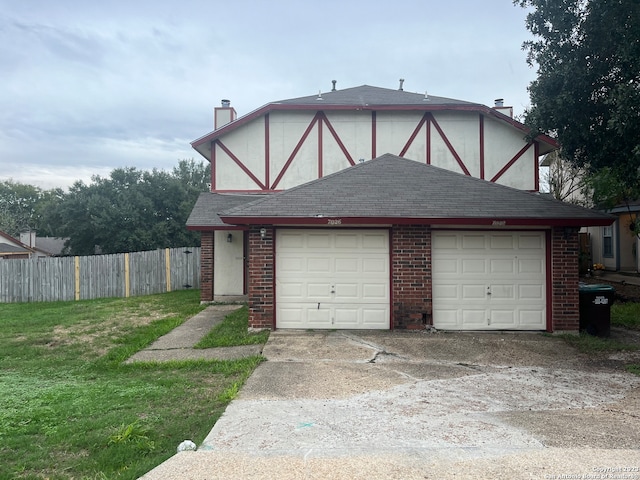 tudor house with a garage and a front yard