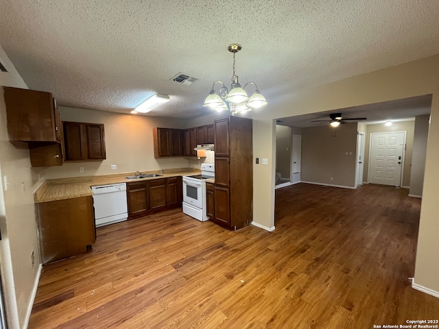 kitchen featuring a textured ceiling, ceiling fan with notable chandelier, white appliances, decorative light fixtures, and light hardwood / wood-style flooring