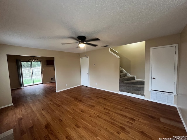 spare room featuring a textured ceiling, ceiling fan with notable chandelier, and dark hardwood / wood-style flooring