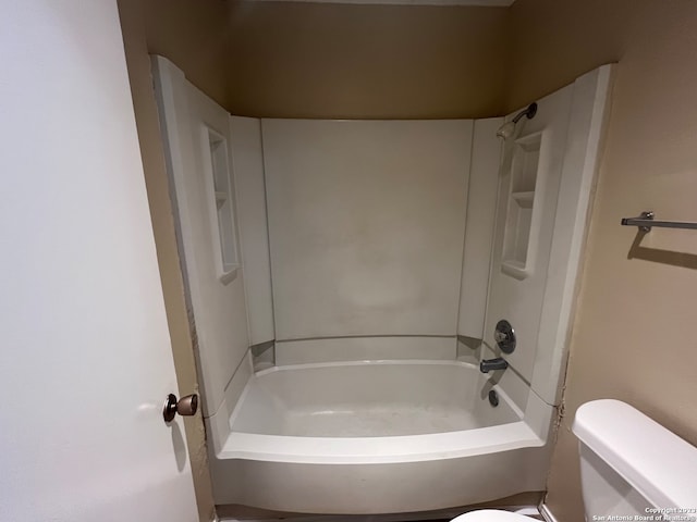 bathroom with washtub / shower combination and toilet