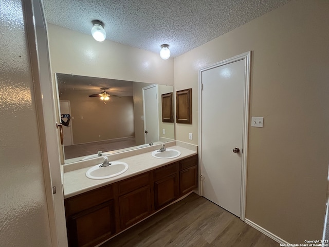 bathroom featuring vanity, a textured ceiling, hardwood / wood-style floors, and ceiling fan